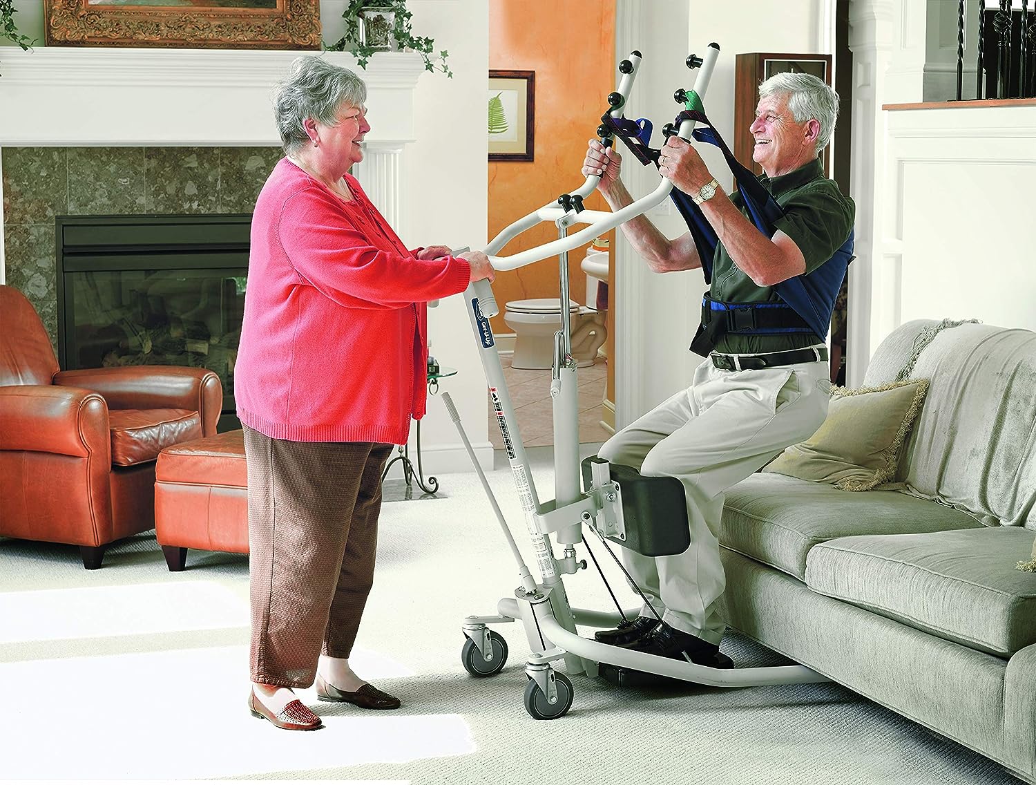 A woman assisting a male from the a sitting position using the Invacare GHS350 Get-U-Up Hydralic Sit-to-Stand Patient Lift.  